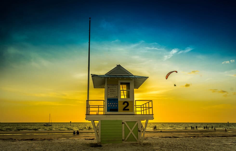 Boardwalk Resort Vacations Reviews shows a Clearwater Beach sunset with a lifeguard tower and evening coastal scenery.